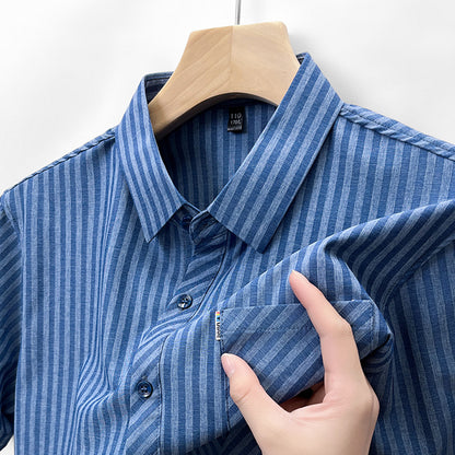 Detail of denim blue stripe men's shirt showing collar chest pocket and linen-feel surface